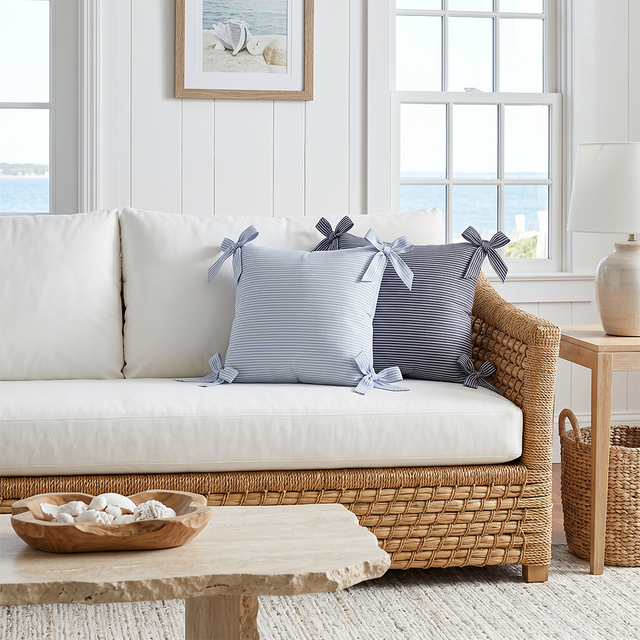 striped bow pillows on white wicker coastal sofa