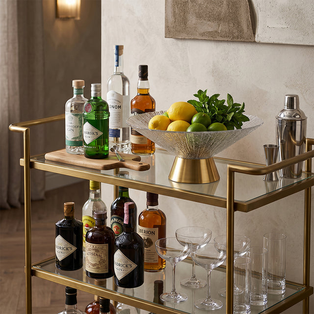 textured glass gold base fruit bowl with fruits on bar cart