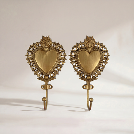 two antique brass heart wall hooks