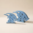 two blue wooden geometric dolphin figurines