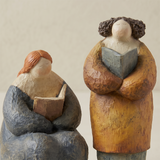 two pebble figurines hugging close up