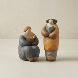 two pebble figurines on plain background