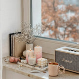 two pink mold-poured candles near the window