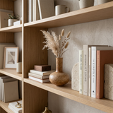 vase on bookshelf with books