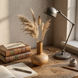 vase on desk with books and flowers