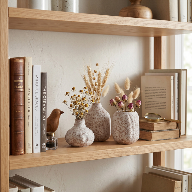 vases with dried flowers on wooden shelf
