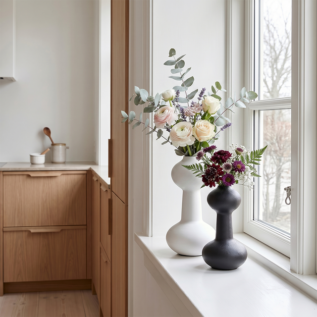 vases with flowers on windowsill in kitchen