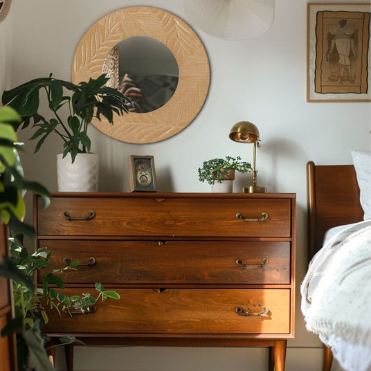 vintage carved wooden round mirror on the wall 