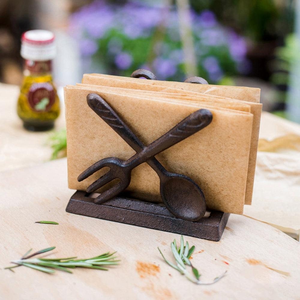 vintage cast iron brown fork knife shaped napkin holder on the table