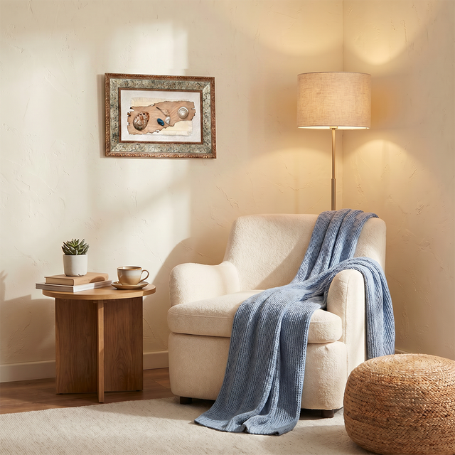 vintage shell art above reading chair with lamp