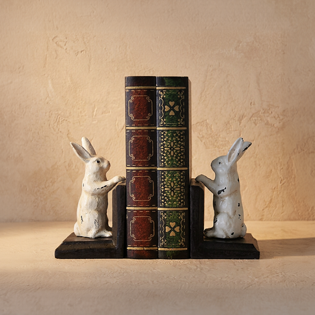 vintage white rabbit bookends holding books