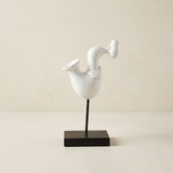white abstract saxophone player sculpture on stand