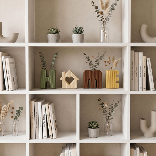 white bookshelf decor with letter vases and books