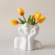 white ceramic face vase with yellow tulips