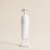 white figurine wearing dress and sun hat