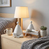 white figurines on nightstand near lamp
