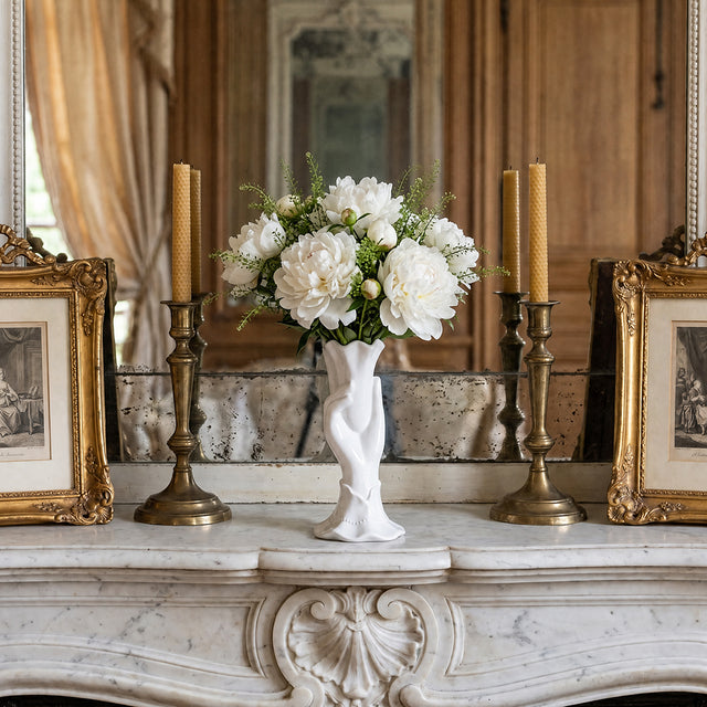 white hand vase with peonies on marble mantel