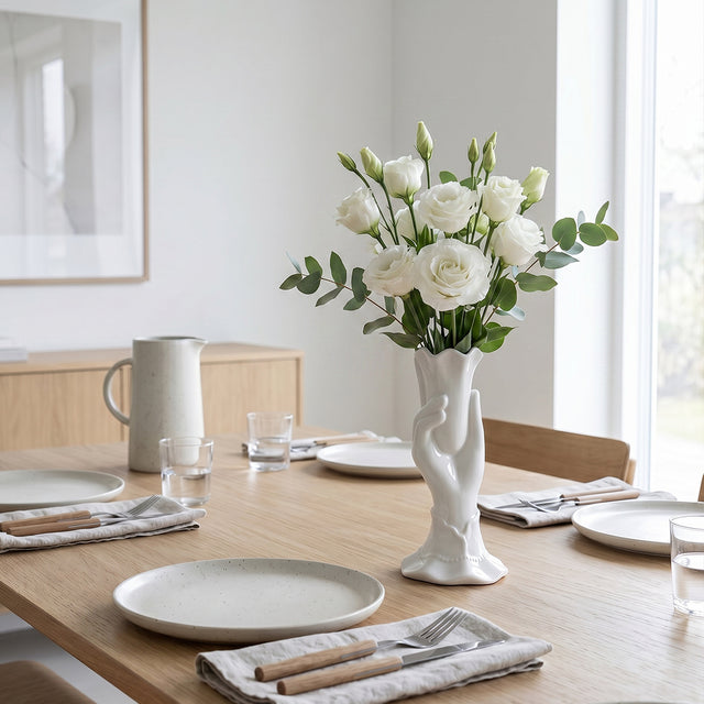 white hand vase with white roses on dining table