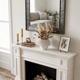 white loop vase with dried flowers on white mantel