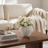 white loop vase with white flowers on coffee table