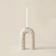 white porous stone arch candle holder