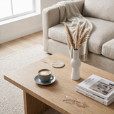 white ribbed vase with pampas on wooden coffee table