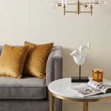 white sculpture on marble side table with magazine