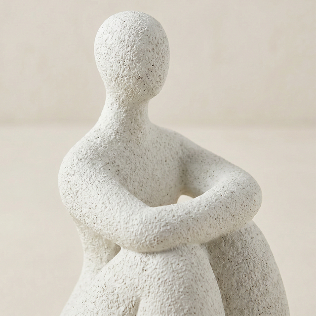 white-seated-human-sculptures