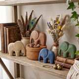 wooden elephants on wooden shelf with dried flowers