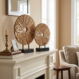wooden sunburst sculptures on mantel with books
