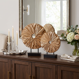 wooden sunburst sculptures on sideboard with flowers