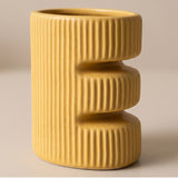 yellow E letter ceramic vase detail shot